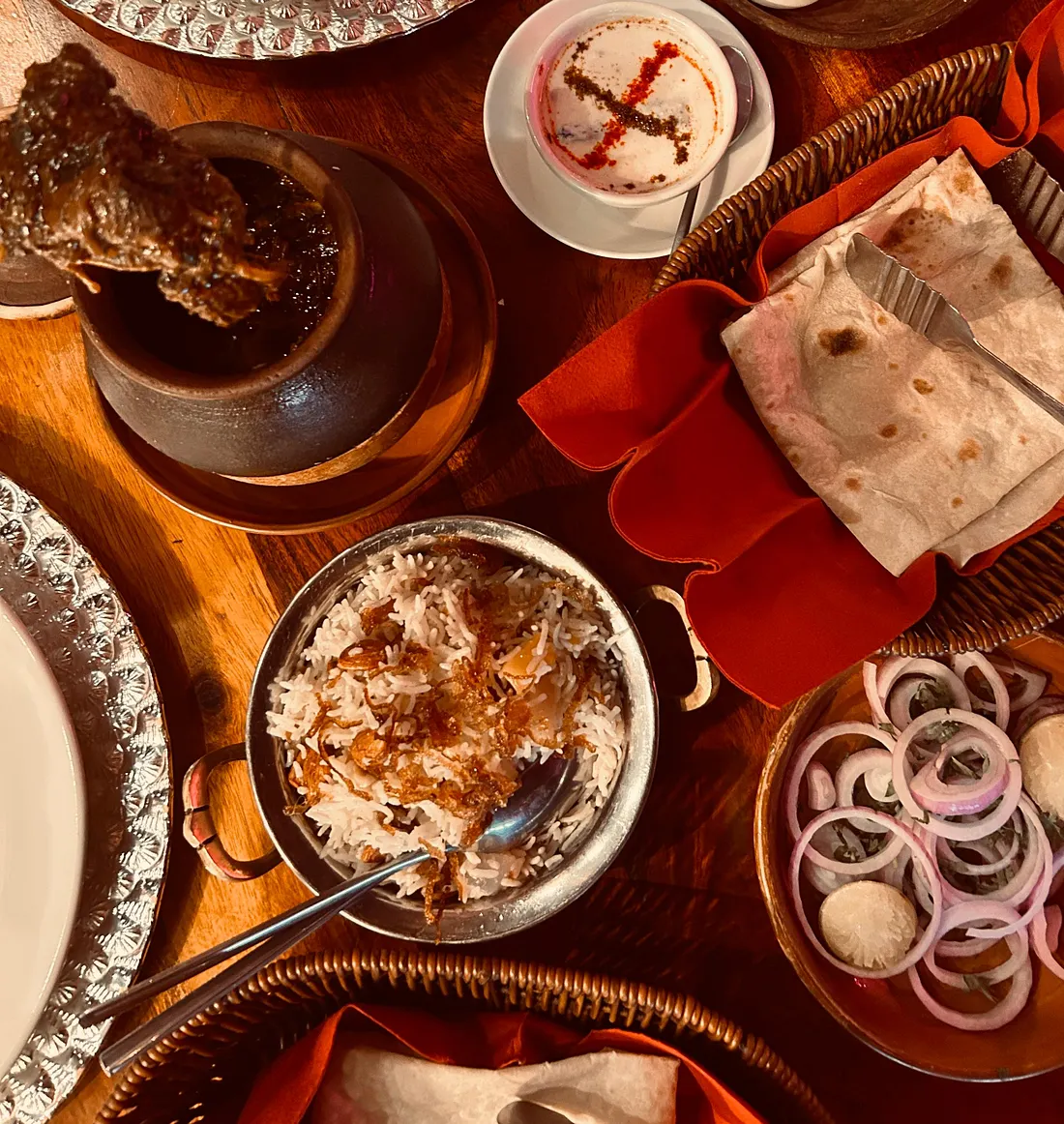 A stylish wavy bowl of creamy butter chicken garnished with herb at Gulaabo Ji